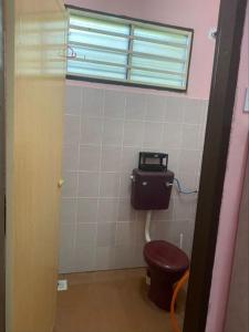 a bathroom with a toilet and a window at De'Lakeside musslim's homestay in Raub