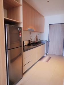 a kitchen with a stainless steel refrigerator at RDHomeStay-RoxyBeachApt in Sematan