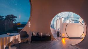 Habitación con ventana redonda y mesa. en Miluna, en Hormigos