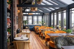 a dining room with tables and chairs and windows at The Martello Hotel in Bray