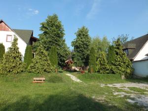 um quintal com árvores e um parque infantil à distância em Gaz69 vendégház em Szilvásvárad
