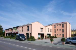a building on a street with cars parked in front of it at BEST WESTERN Titian Inn Hotel Venice Airport in Tessera
