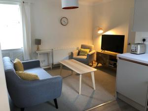 a living room with two chairs and a tv at Smugglers Neuk - cosy hideaway for 2 in Cellardyke in Cellardyke