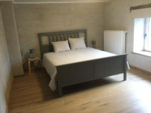 una camera da letto con un letto con lenzuola bianche e una finestra di Maison Druyard huis met 5 slaapkamers a Durbuy