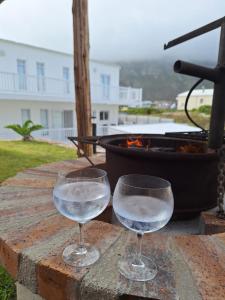dos vasos de agua sentados en una mesa con una parrilla en Nivenia Beach House en Bettyʼs Bay