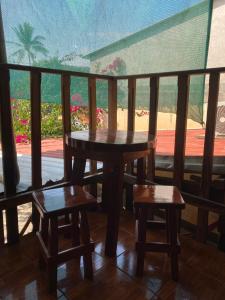 a table and two stools on a balcony with a view at Hotel Pacific Surf Best Room In Tunco Beach Surf City in El Sunzal