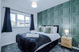 - une chambre avec un grand lit et un mur vert dans l'établissement Charming Home in Mossley with Free Parking and Wi-Fi Sleeps7, à Mossley