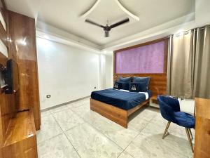 a bedroom with a blue bed and a window at Very spacious terrace with rooms for holi party in Gurgaon