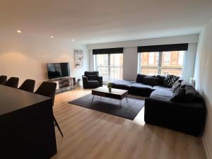 a living room with a couch and a tv at City Centre Apartment w Parking & Hyperoptic Wifi in Glasgow
