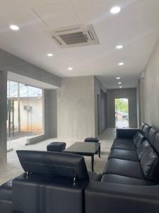 a living room with black leather couches in a room at 365 View Point Resort in Kaki Bukit