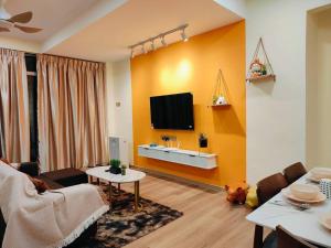 un soggiorno con un divano e una TV di Orange Tatami Funny House at Bukit Beruang Malacca a Malacca