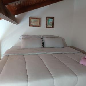 Cama en habitación blanca con 2 almohadas en Residencial Terra Pura, en Prado