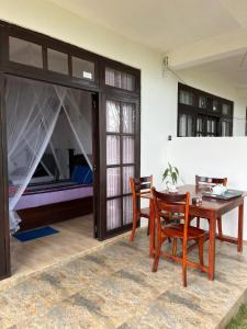 a dining room with a table and chairs and a bed at Saveen View Ella in Ella