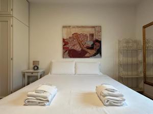 a bedroom with a white bed with towels on it at Welc-ōM luxury place in the hill in Galzignano