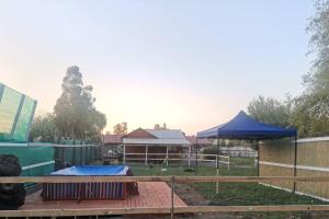einen Hof mit einem Zaun und einem blauen Zelt in der Unterkunft Cabaña El Quillay in Linares