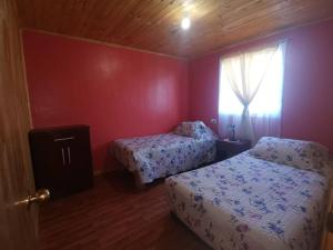 a bedroom with two beds and a window at Cabaña El Quillay in Linares