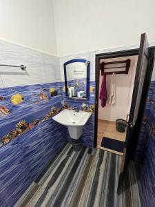 een badkamer met een wastafel en een vismuurschildering aan de muur bij Saveen View Ella in Ella