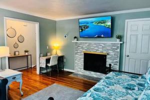 een woonkamer met een open haard en een tv erboven bij Amherst Country OASIS Perfect Location UMass in Hadley