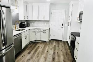 een keuken met witte kasten en een houten vloer bij Amherst Country OASIS Perfect Location UMass in Hadley