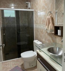 Un baño con ducha, inodoro y lavabo. en Casa no centro de Porto Belo, en Porto Belo