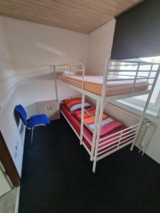 Zimmer mit 2 Etagenbetten und einem blauen Stuhl in der Unterkunft Monteur- und Ferienwohnung Siegen Miller in Siegen
