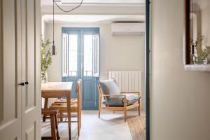 Zimmer mit einem Tisch und einer blauen Tür in der Unterkunft SEISSTA Madrid Centro "Remodelado" in Madrid