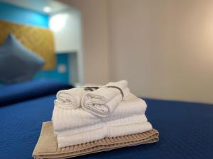 una pila de toallas sentadas encima de una cama en Coastal House - Spiaggia e Piscina a dieci passi, en Santa Marinella