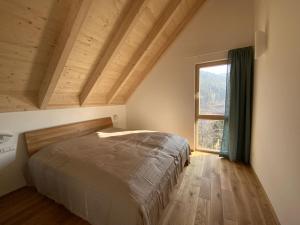 um quarto com uma cama e uma grande janela em Ferienhaus Baiersbronn LUG INS TAL em Baiersbronn