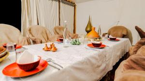 einen Tisch mit orangefarbenen Platten und Schalen darauf in der Unterkunft Nomad Camp in Erfoud