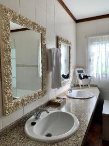 a bathroom with two sinks and a large mirror at Casa Da Noquinhas in Bunheiro