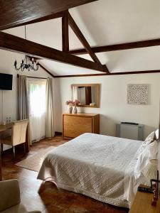 a bedroom with a bed and a desk and a window at Casa Da Noquinhas in Bunheiro