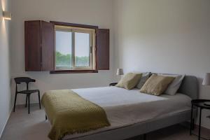una camera da letto con un grande letto e una finestra di Em Casa Deles - Herdade do Gizo, Cuba a Beja