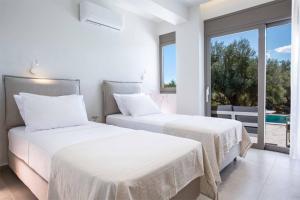 two beds in a room with a view of the ocean at Villa Averto Irene in Ráchi