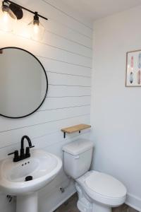 a white bathroom with a sink and a toilet at Ocean Lofts in the Vibe #4 - 5 min walk to beach in Virginia Beach