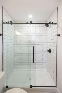 a shower with a glass door in a bathroom at Ocean Lofts in the Vibe #4 - 5 min walk to beach in Virginia Beach
