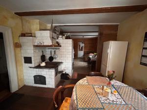 a kitchen with a table and a brick oven at Uroczysko Grabowiec in Grabowiec