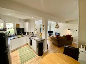 a kitchen and living room with a couch and a table at Pass the Keys Delightful Cottage Sydney Gardens private parking in Bath