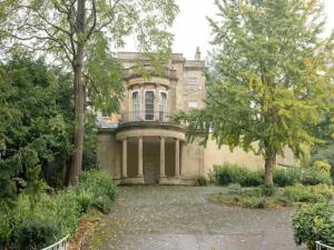 an old mansion with trees and a driveway at Pass the Keys Delightful Cottage Sydney Gardens private parking in Bath