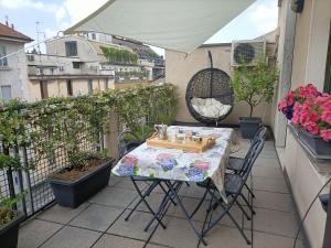 einen Tisch und Stühle auf einem Balkon mit Pflanzen in der Unterkunft Coni Zugna in Mailand