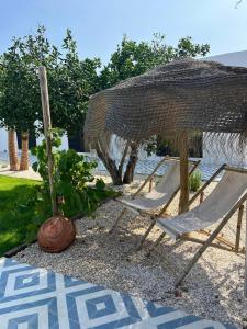 a couple of chairs and an umbrella on the beach at CasaNoa Boutique Guest Suites in Jávea