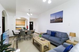RH-Near Mall of Emirates, Spacious & Bright 02 BR في دبي: غرفة معيشة مع أريكة زرقاء وطاولة