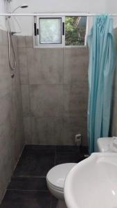 a bathroom with a toilet and a sink and a window at Casa de playa para vacacionar in Las Toscas