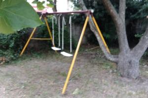 a swing set in front of a tree at Casa de playa para vacacionar in Las Toscas