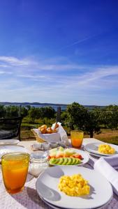 a table with plates of food and orange juice at Montimerso Skyscape Countryhouse in Monsaraz