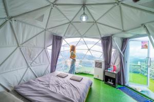 Uma mulher está num quarto numa tenda cúpula. em MonLannaHomesty em Mon Jam