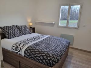 a bedroom with a bed and a window at Les maisons de la feuillade in Milhac-dʼAuberoche