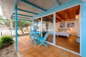 a patio with a blue table and a bed at Ponent in Es Caló