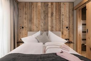 a bedroom with a white bed and wooden walls at Resort Schrofenblick in Mayrhofen +34 photos