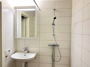 a white bathroom with a sink and a shower at Stay Inn Söder Cozy apartment in Stockholm
