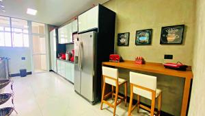 a kitchen with a counter and a refrigerator at Apto cinematográfico vista mar in Guarujá